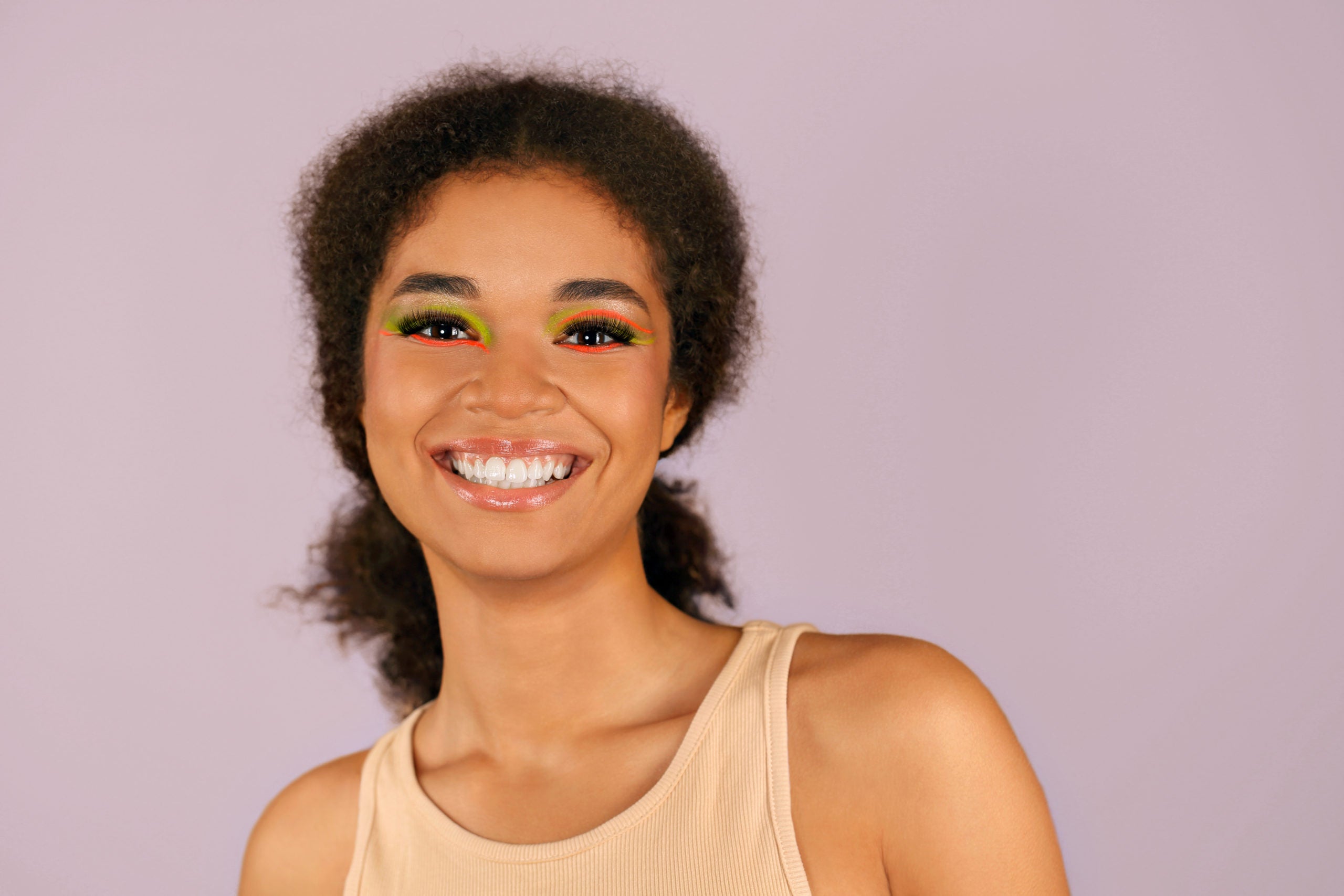 Young woman smiling with colorful graphic eye makeup