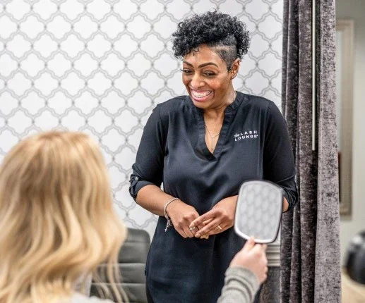 Woman looks in the mirror with her new set of lashes