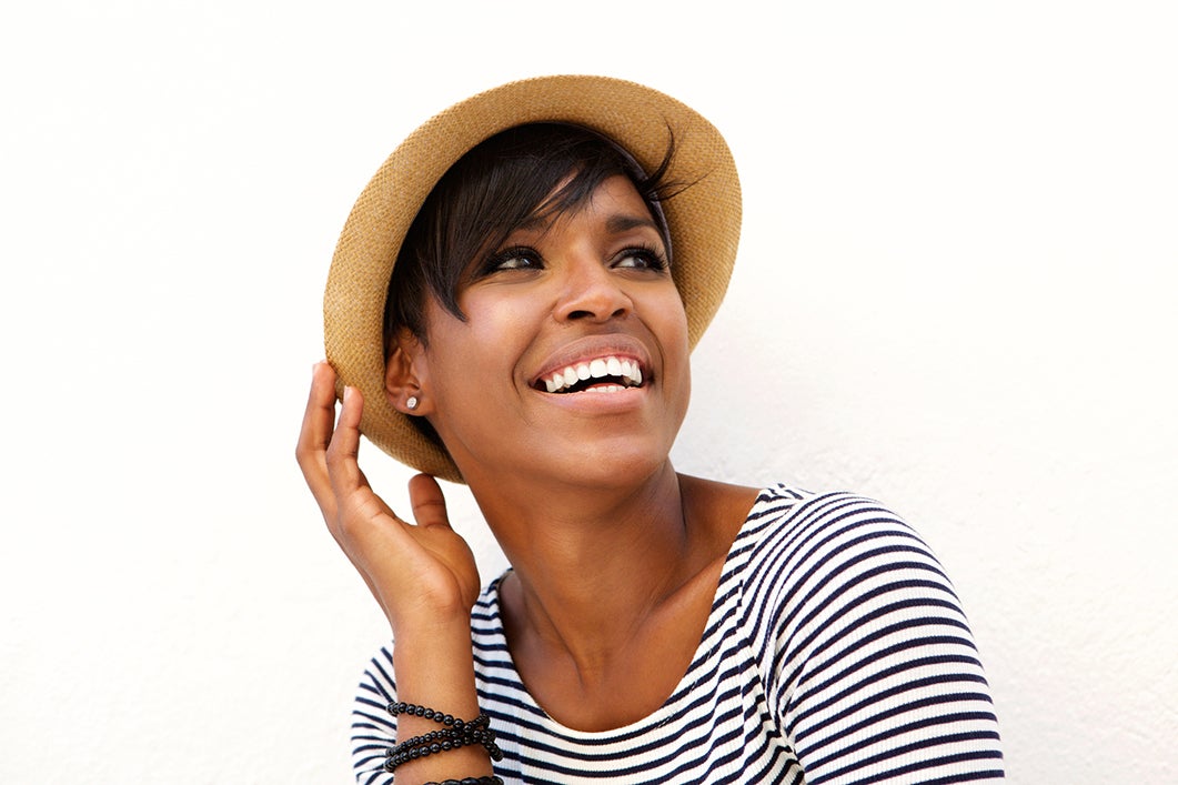 Smiling black woman wearing hat while on vacation
