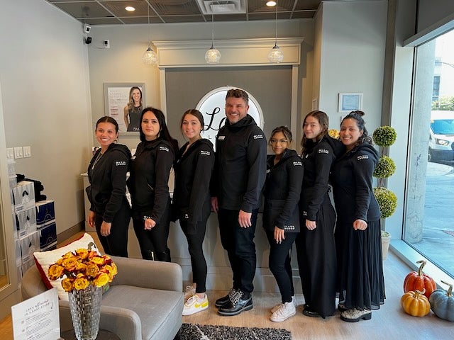 the lash lounge team in front of the front desk