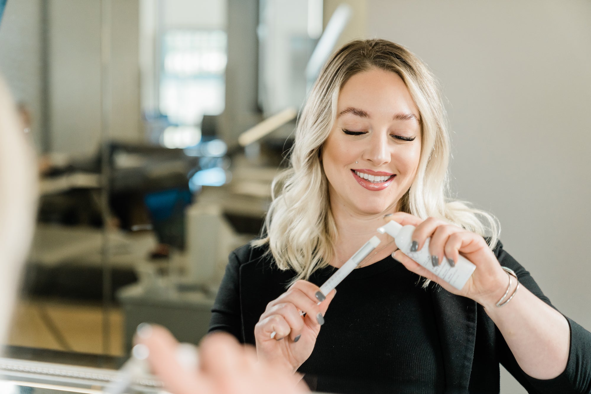 blonde white woman applying lash cleanser to a cleansing brush