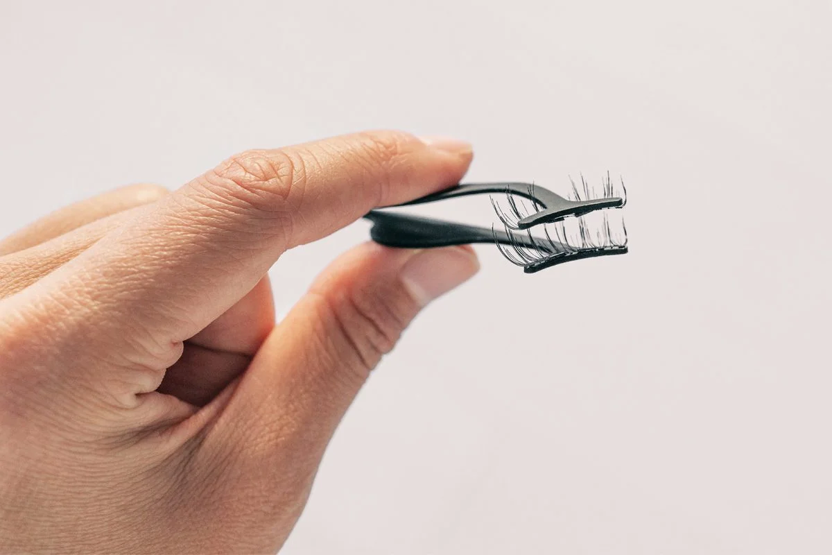 person with tweezers and magnetic lashes