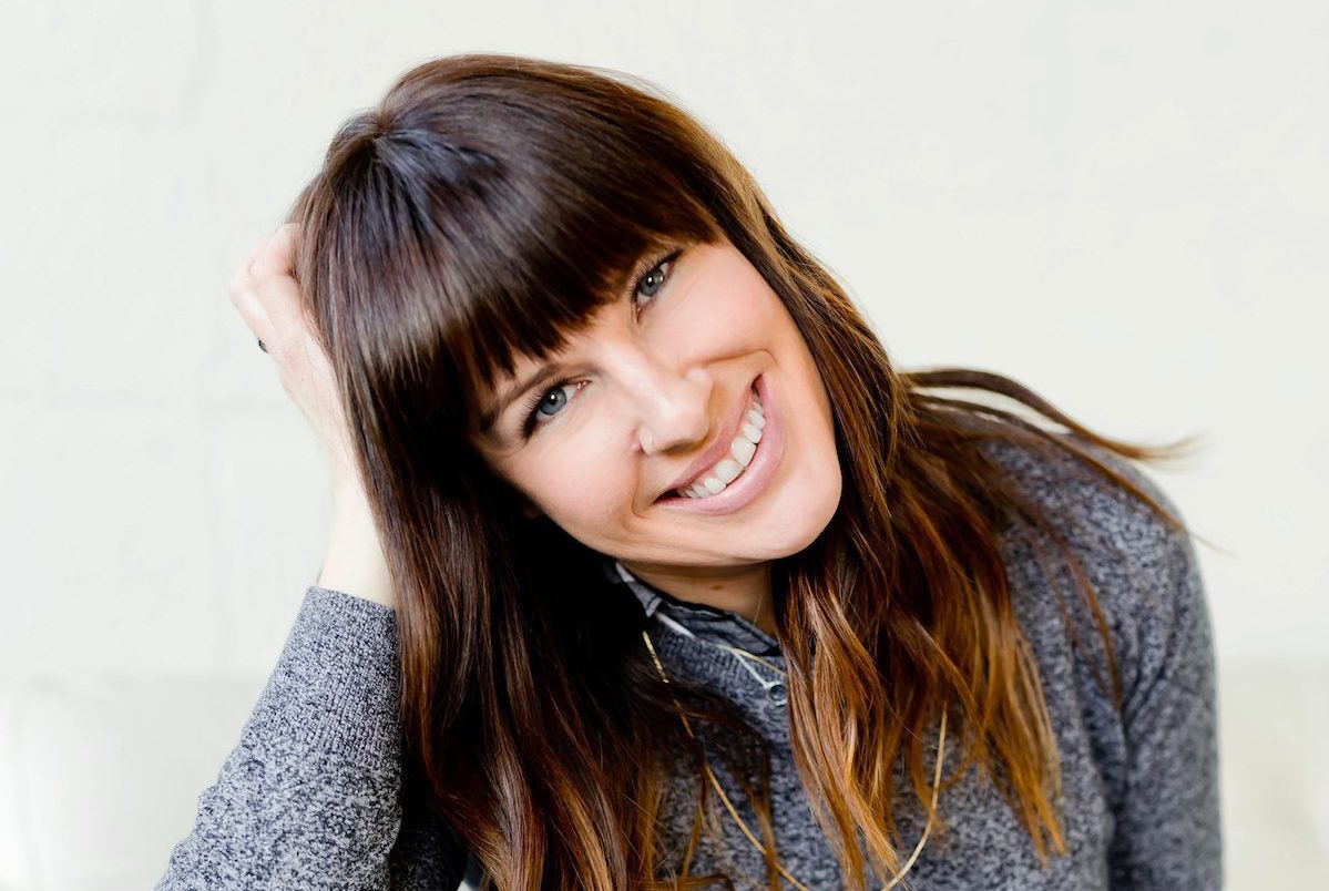 closeup of woman with bangs smiling with lash extensions