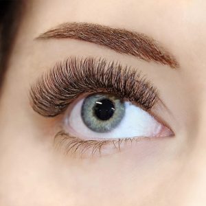 A close-up of a woman's eye and eyelash extensions