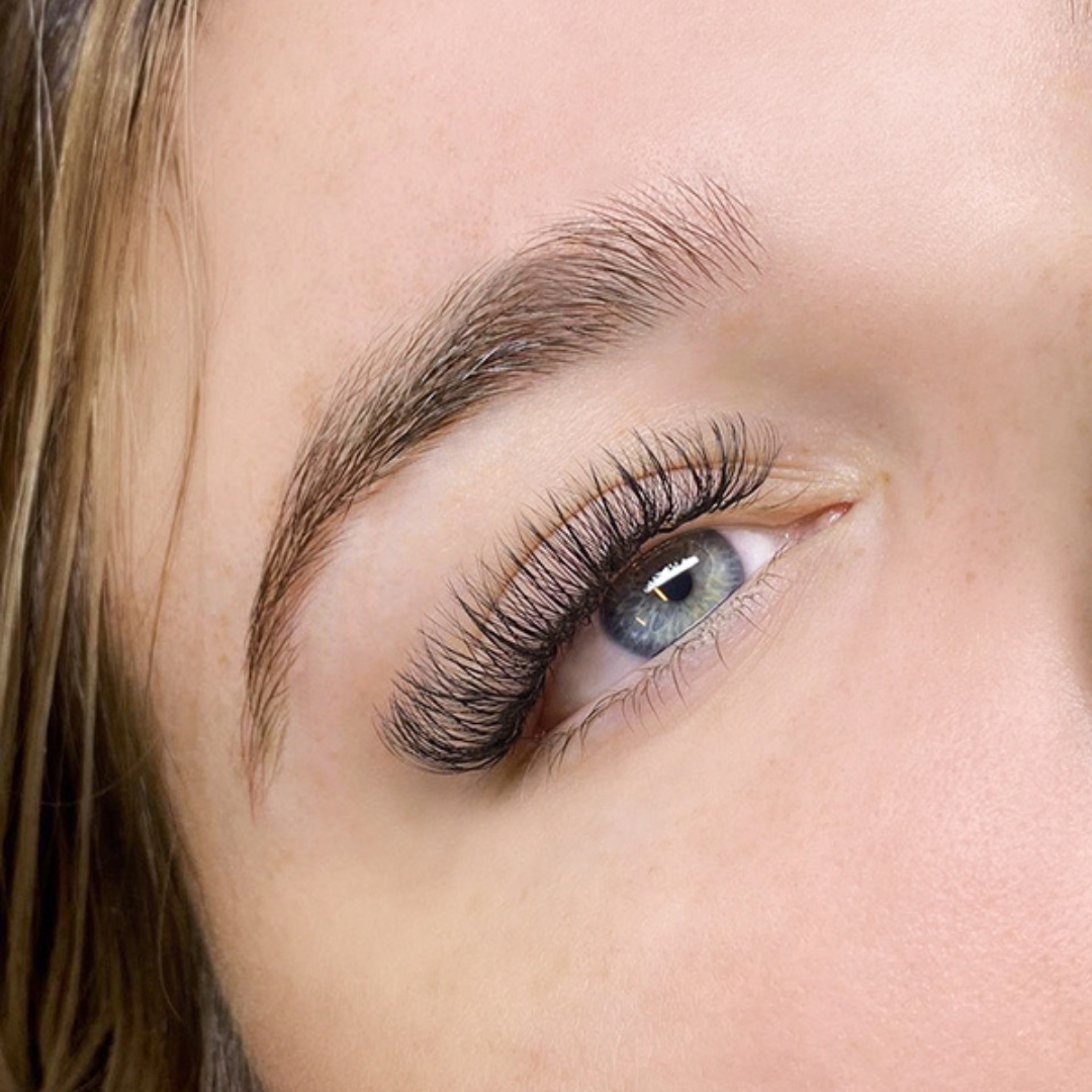 A close-up of a woman's eye with wispy lash extensions