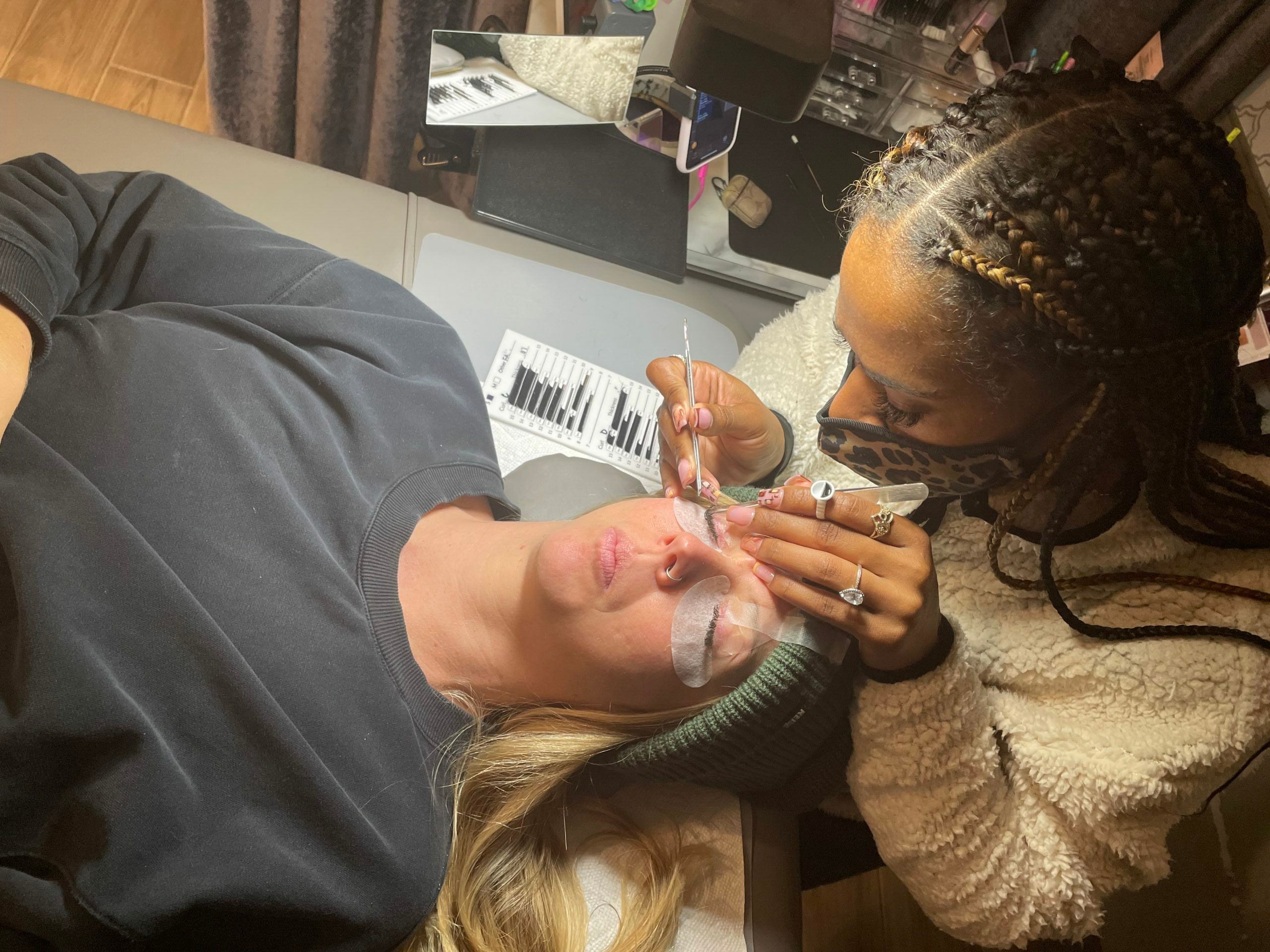 stylist performing lash extension service on guest