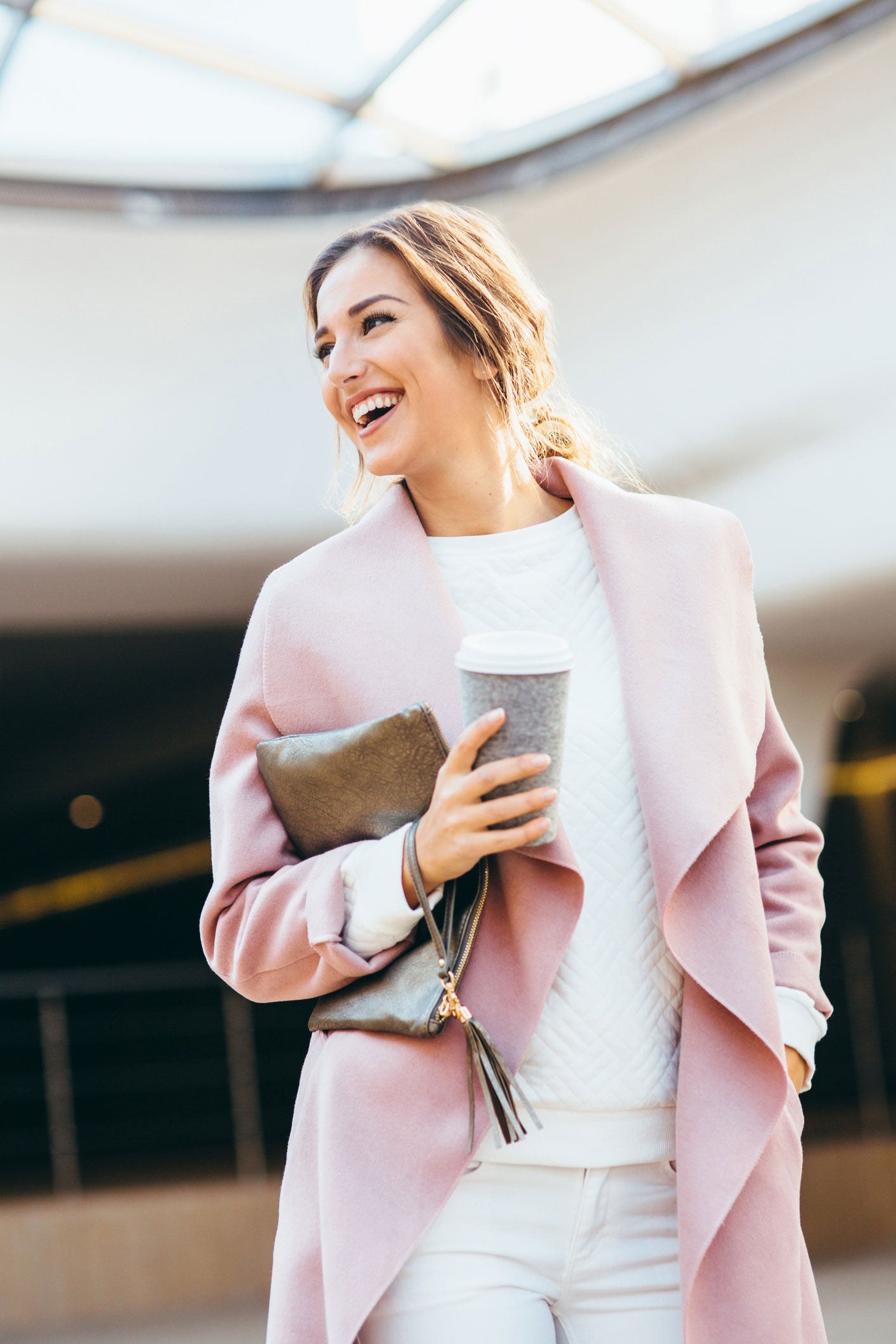 woman in pink cardigan smiling after lash fill