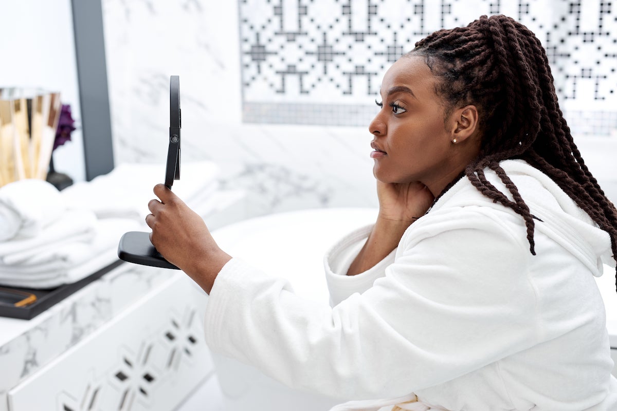 young black woman in bathrobe admiring her lash lift from The Lash Lounge