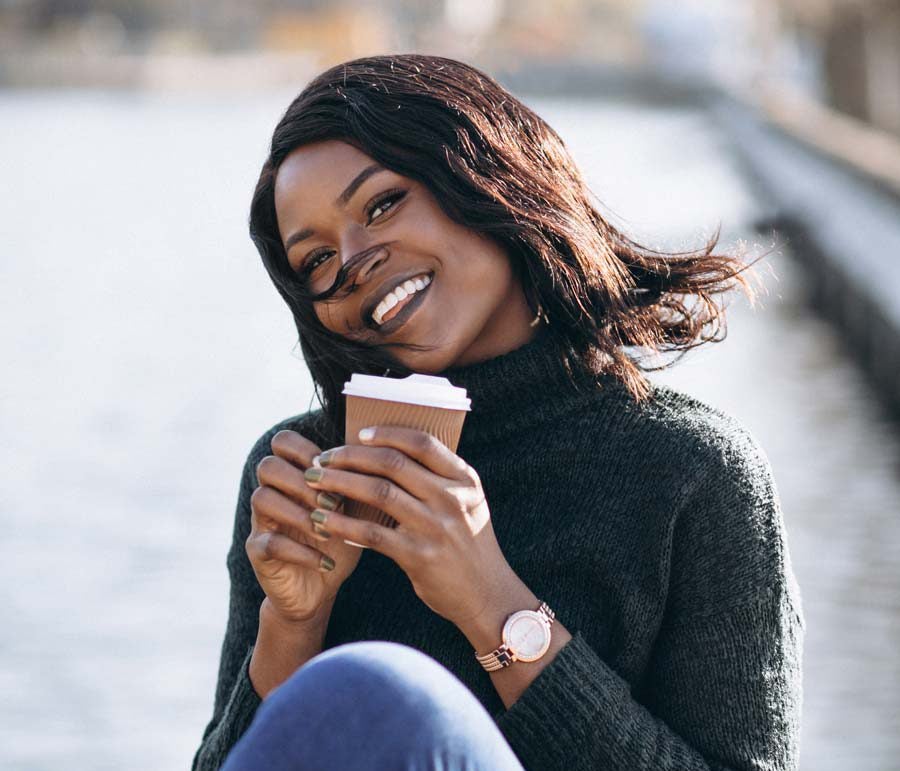 lash lounge guest smiling with a cup of coffee