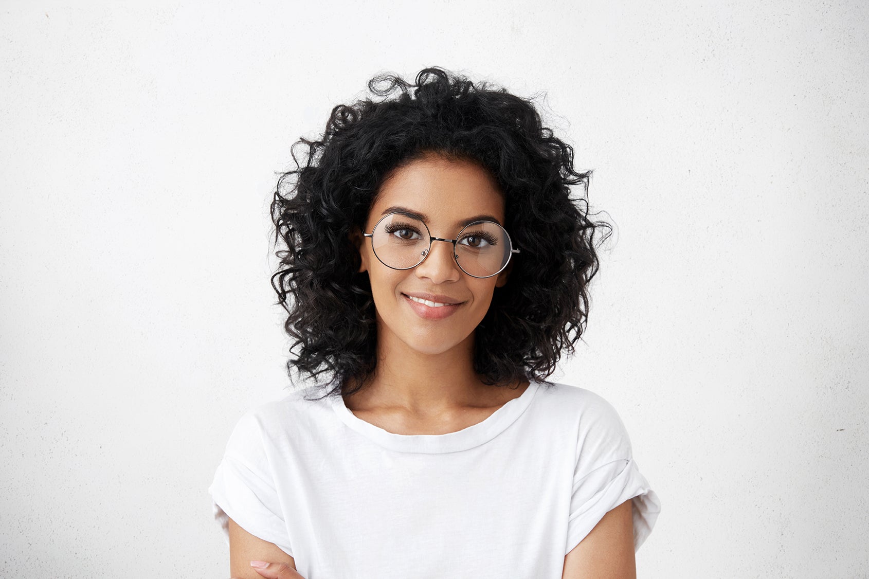 attractive black woman in white tee with curly hair rocking stylish glasses with lash extensions
