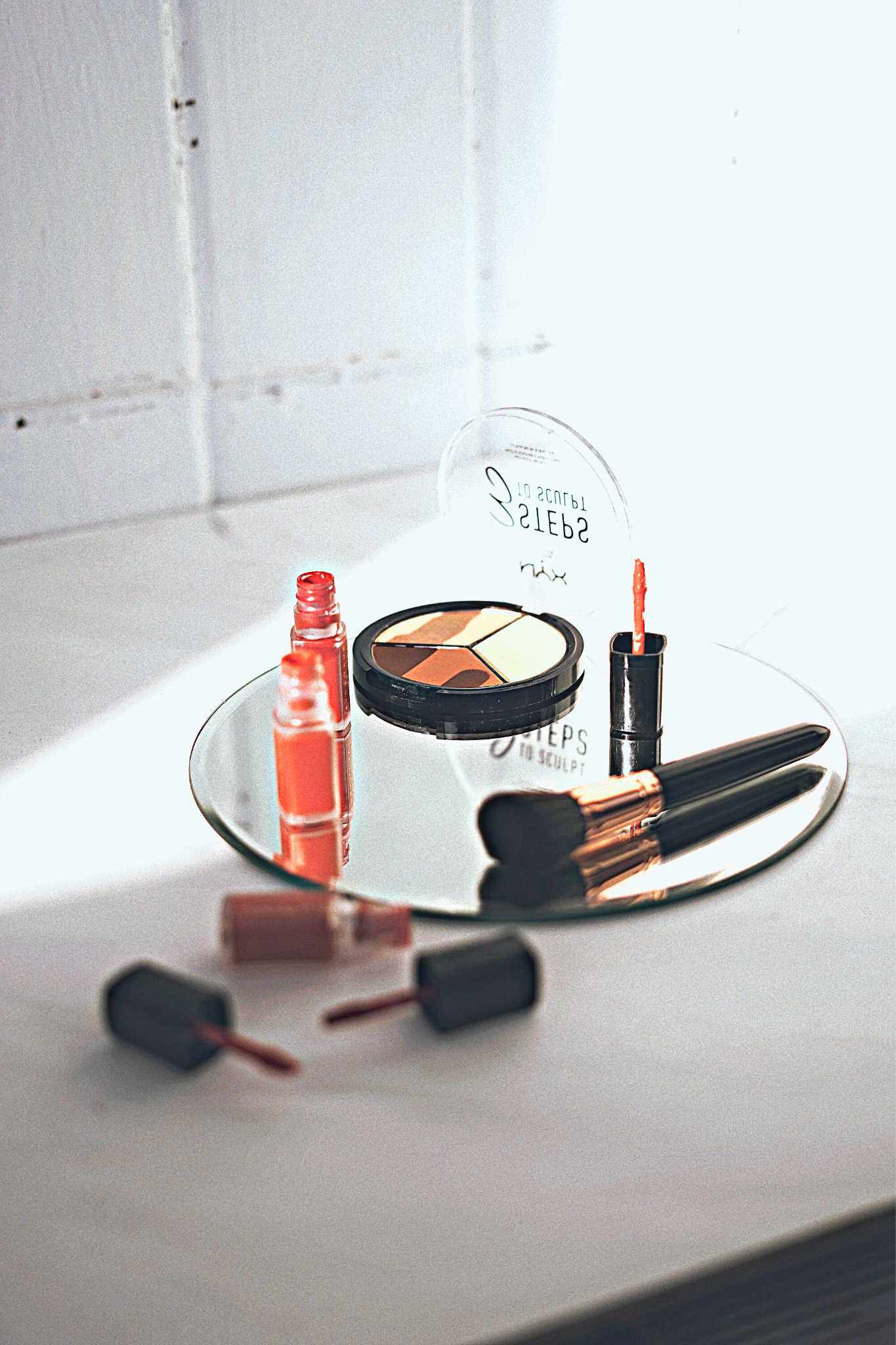 An assortment of warm toned fall makeup resting on a counter