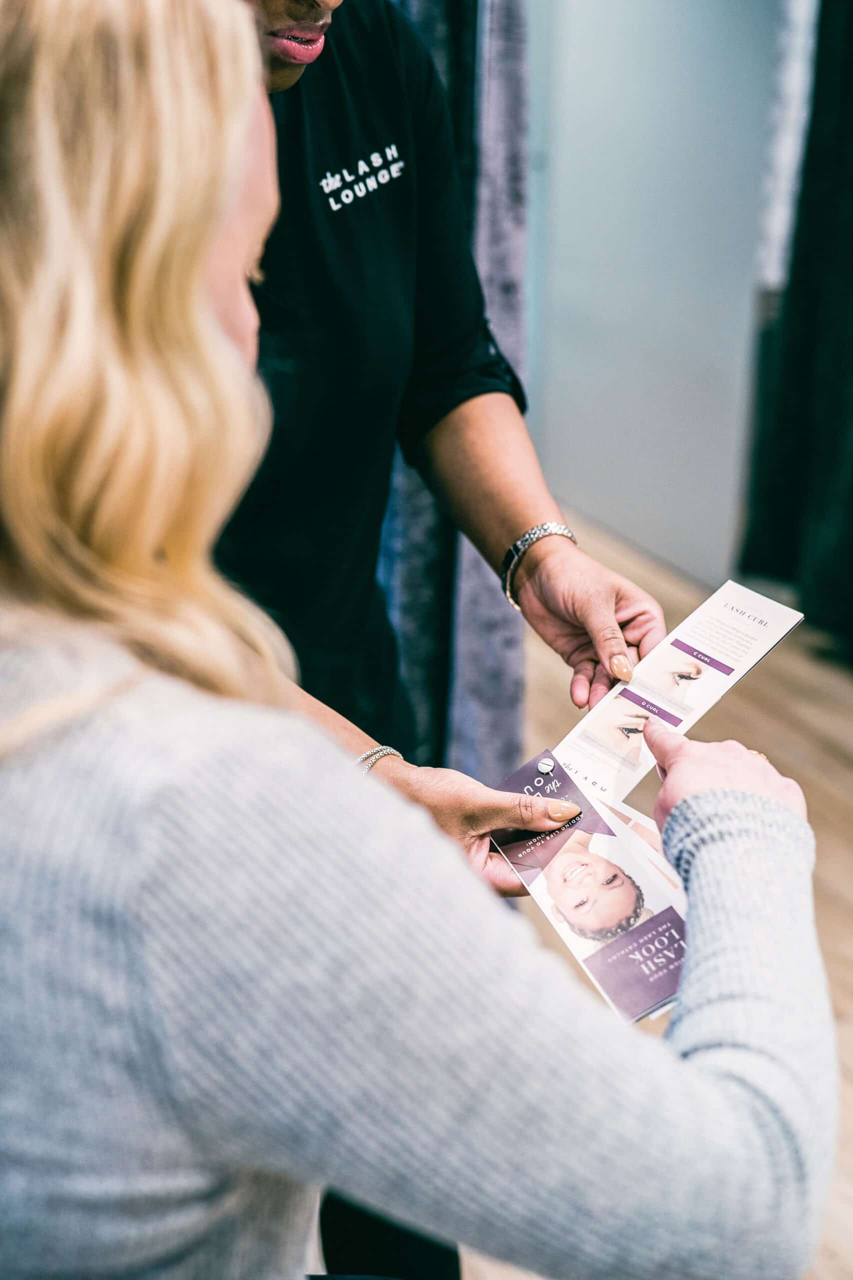 Lash Lounge stylist assists a guest with her lash consultation.