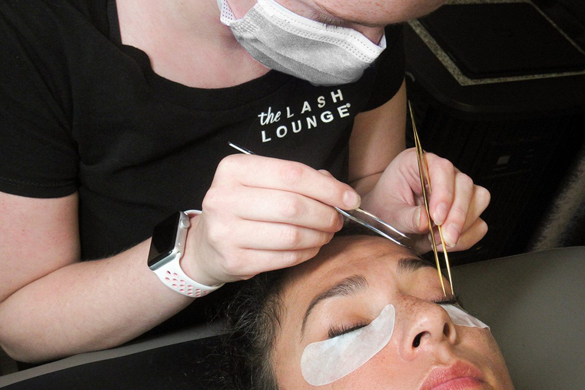 lash stylist from The Lash Lounge applying lash extensions on a guest