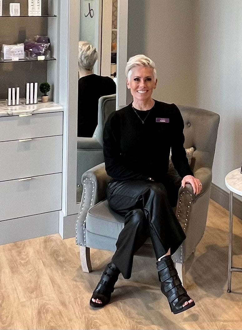salon owner sitting in lobby with legs crossed
