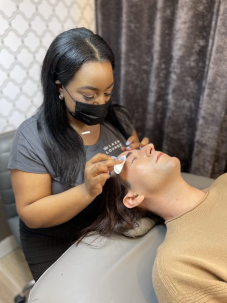 lash stylist performing a brow service on a guest