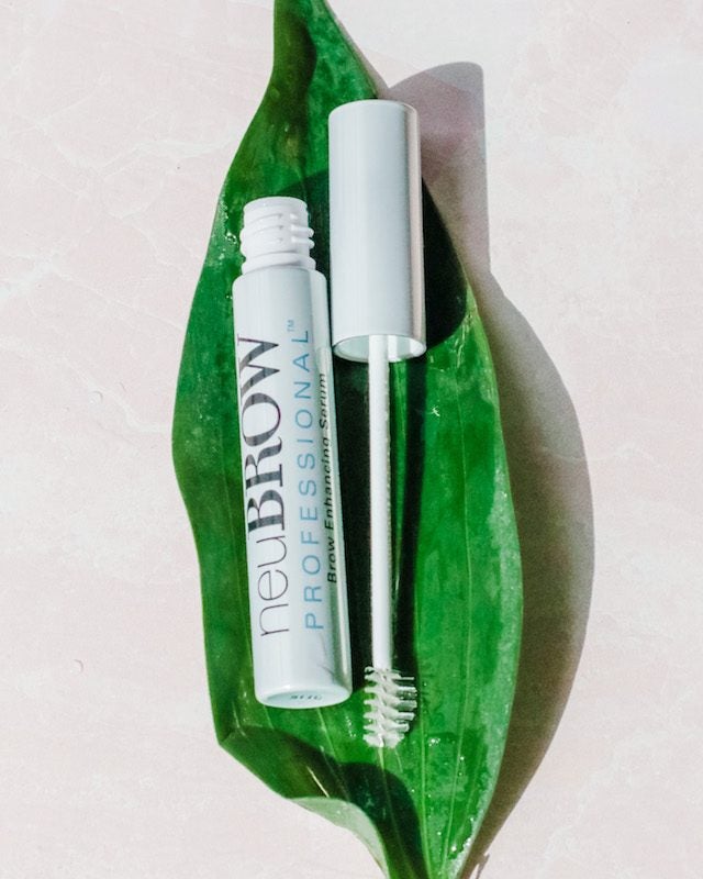 tube of brow serum product neuBROW PROFESSIONAL™ on top of a green leaf