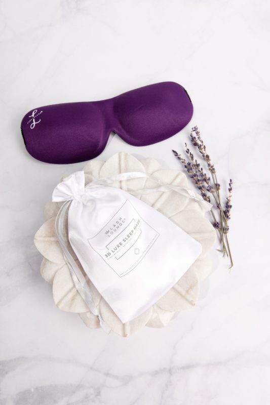 sleep mask for lash extensions with silk storage bag resting on decorative dish