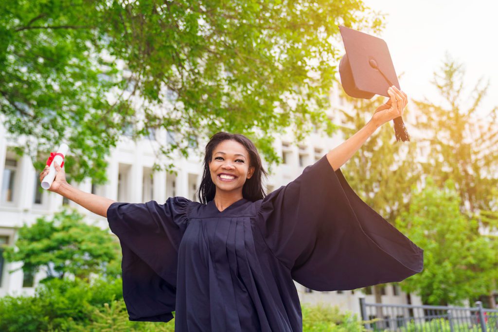 black woman with lash extensions outdoors happy after graduation