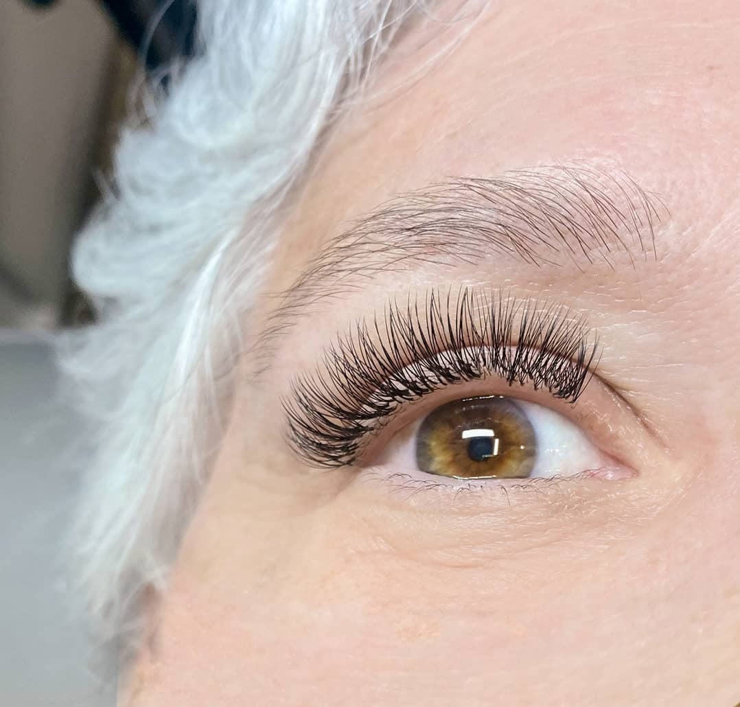 A mature woman with gray hair and custom lash extensions from The Lash Lounge