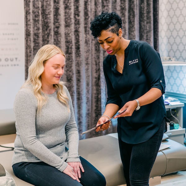 A Lash Lounge stylist chatting with a guest