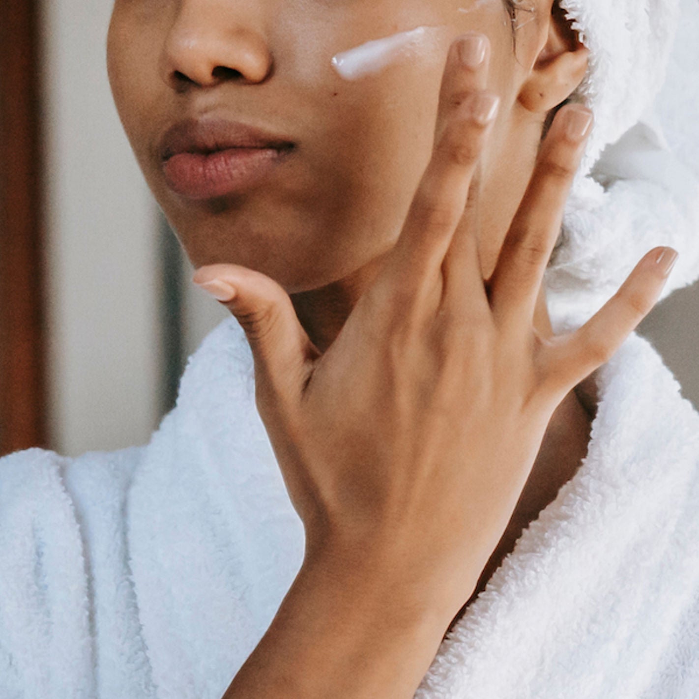 close-up of half of woman's face with moisturizer