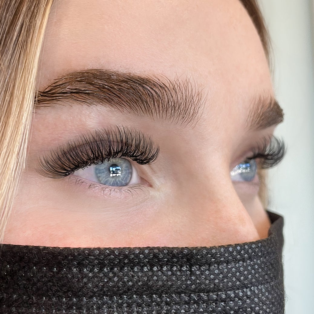 close-up of woman's blue eyes with hybrid lash extensions
