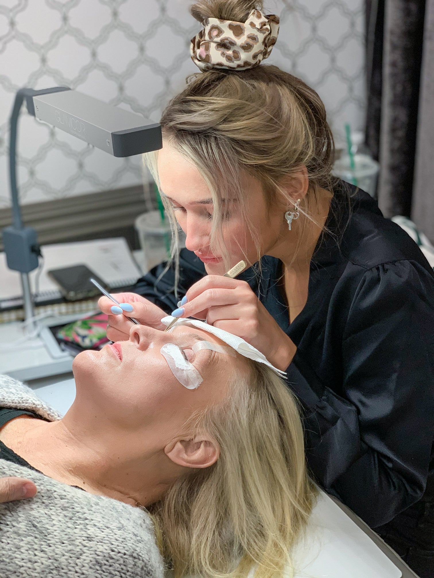 lash stylist performing a lash extension application service