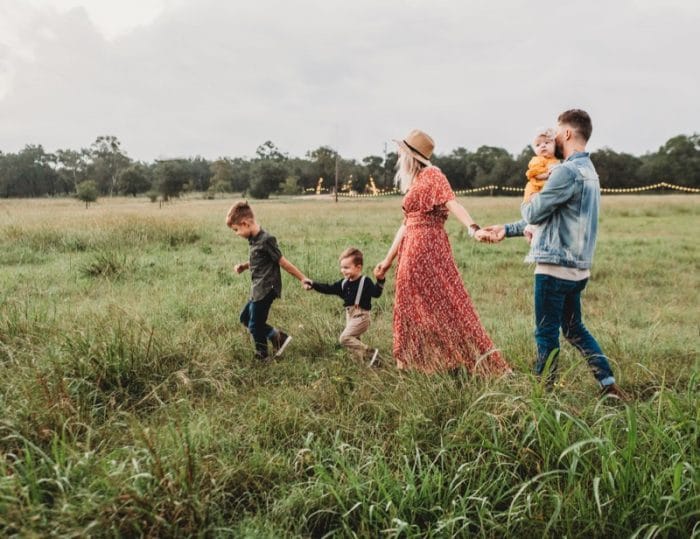 a family of 5 walking through a field