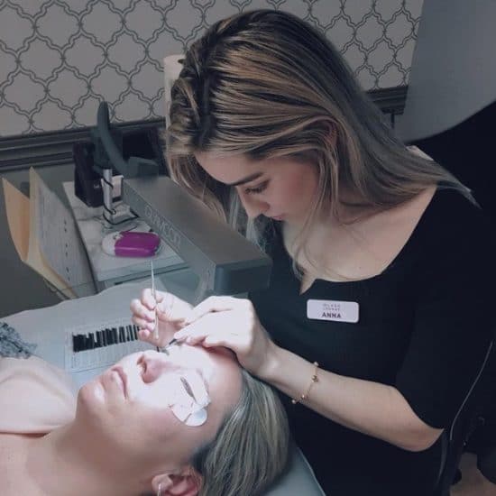 A Lash Lounge stylist performing a lash extensions service on a guest.