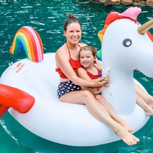 Michelle from Modern Mom, who's also a Lash Lounge guest, sitting on a float in a pool with her daughter.