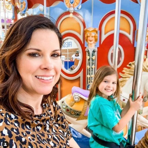 Michelle from Modern Mom Life living the lash life, riding a carousel with her daughter and her lash extensions