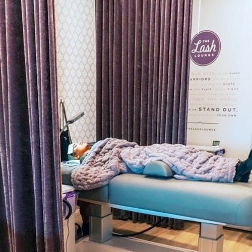 a guest lying in a service bed at The Lash Lounge.