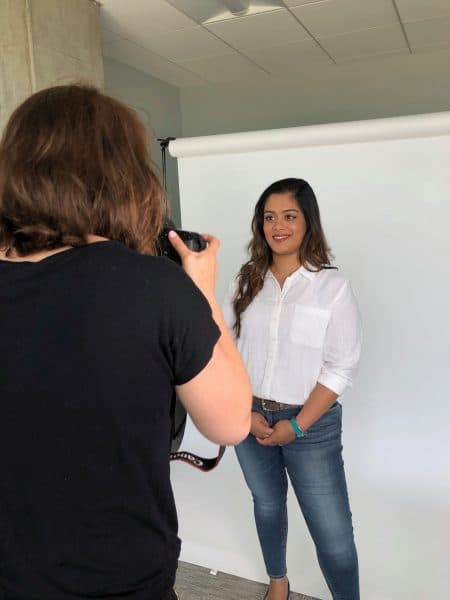 A woman posing for a photoshoot with a professional photographer