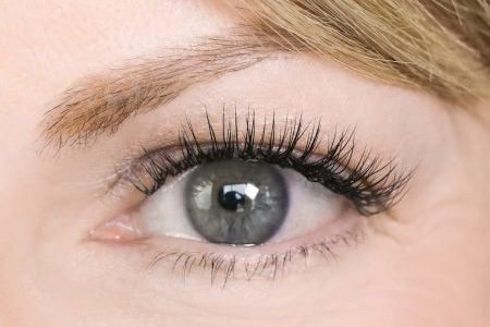 extreme closeup of a real Lash Lounge woman's classic eyelash extensions with a C curl