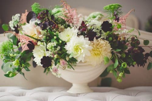 a vase overflowing with various types of flowers