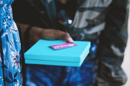 a person holding a blue gift box