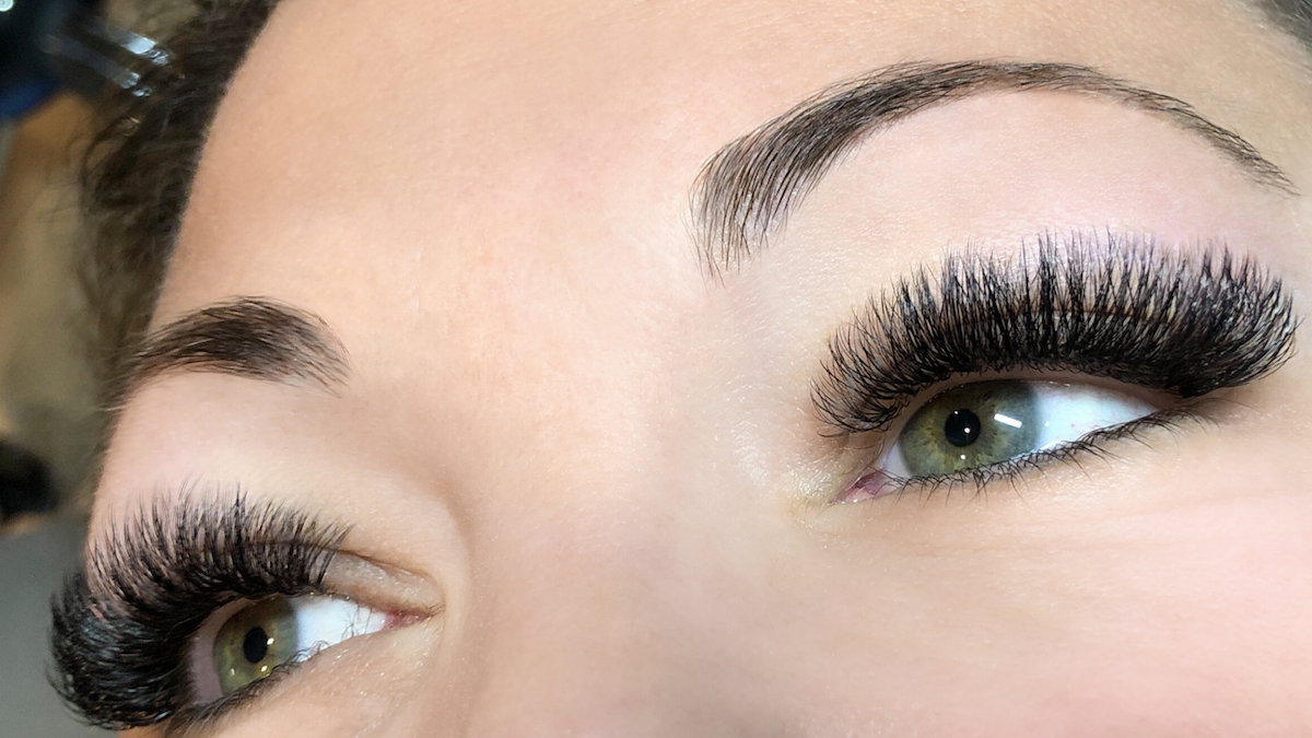 close up of full and voluminous lashes on green eyed woman