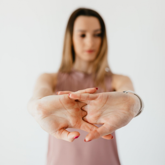 a young woman with her hands out in front of her body as she stretches