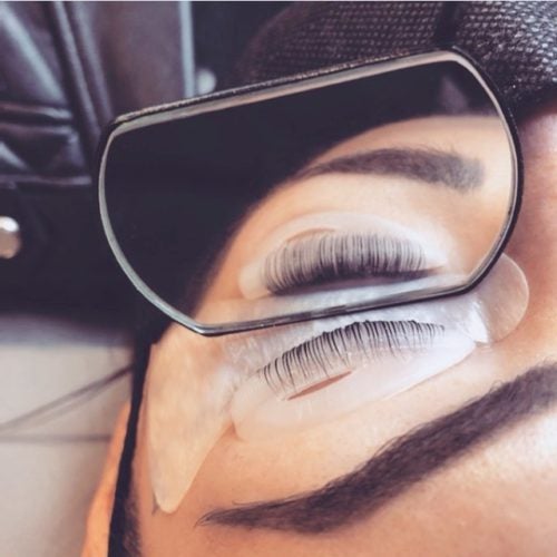 Close-up of a woman's closed eye during a lash lift application