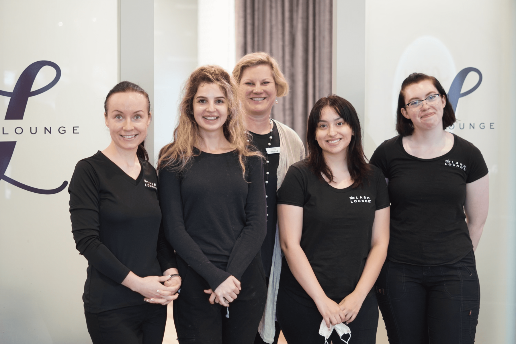 Lash stylists in uniform smiling at The Lash Lounge