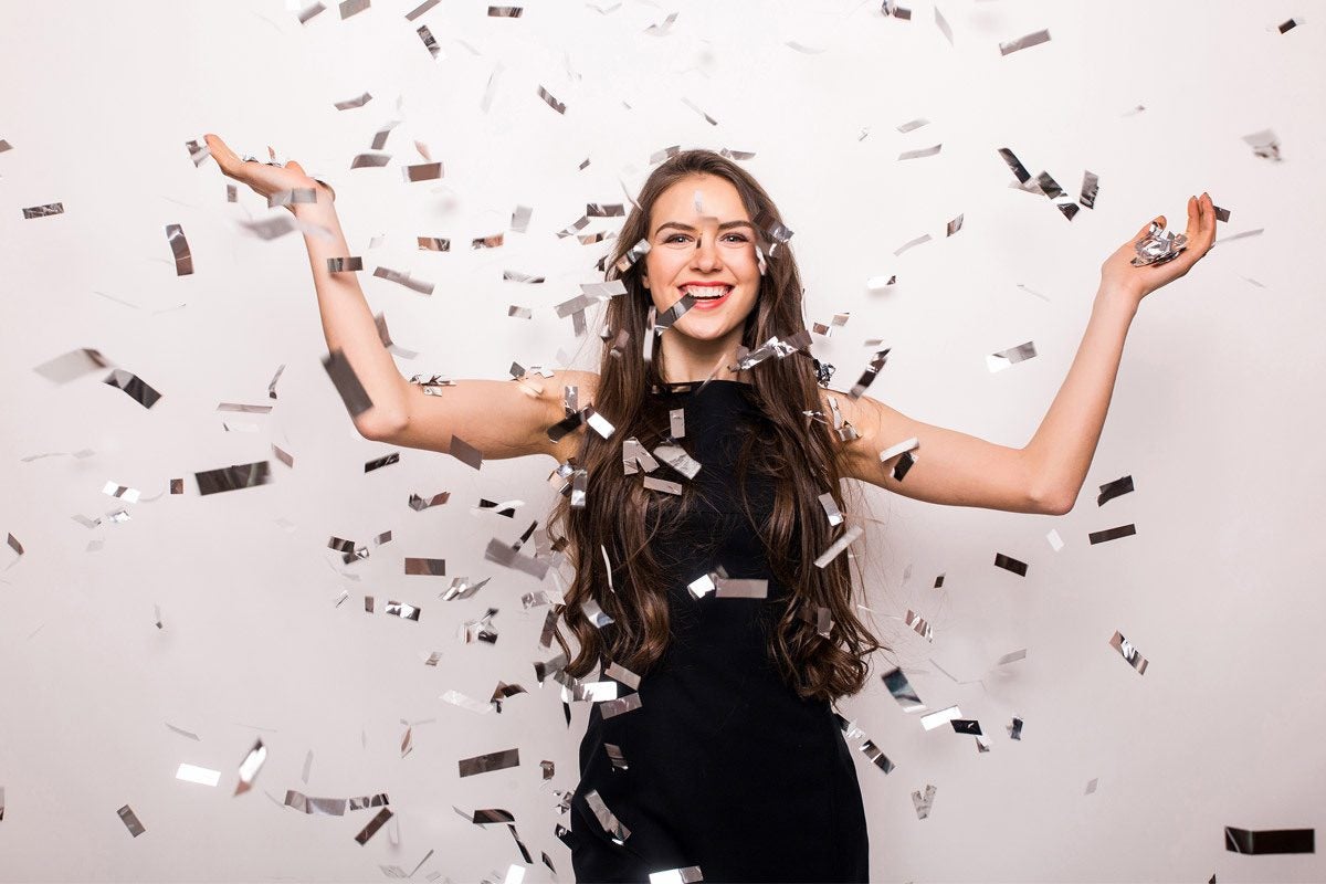 photo of woman in black dress surrounded by confetti
