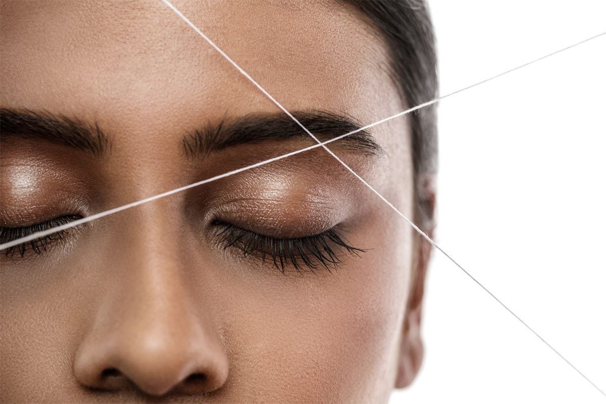 close-up of woman's face during eyebrow threading