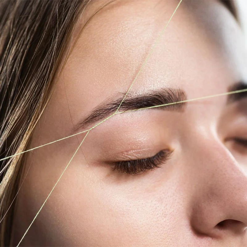 close up of woman's face while having brows threaded