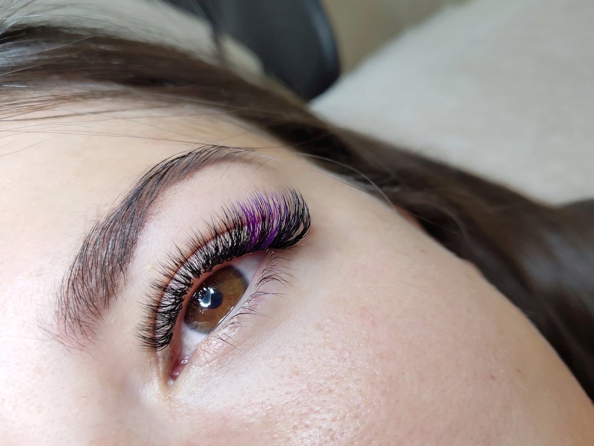 close-up of woman's eye with purple lashes