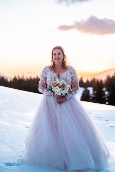 bride in snow smiling with bridal eyelash extensions