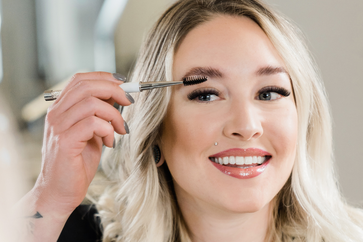 closeup of woman combing her eyebrows