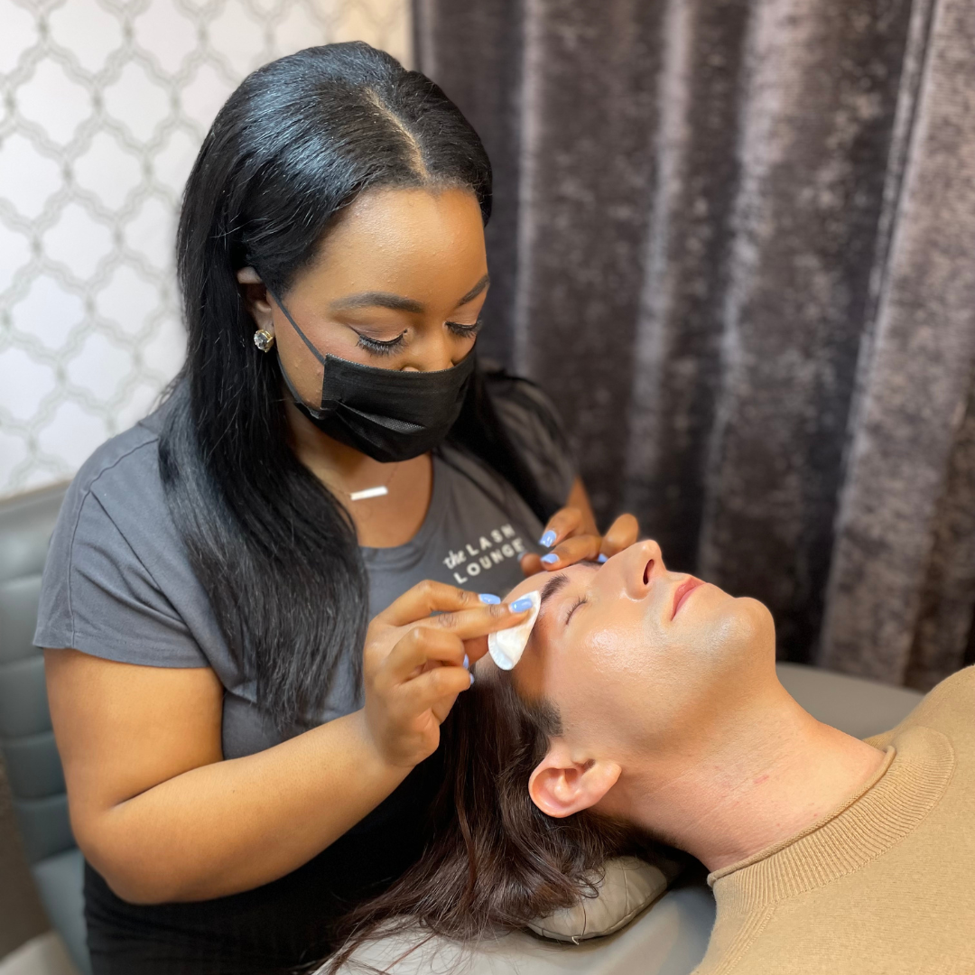 Lash Lounge stylist performing a brow service on a male guest