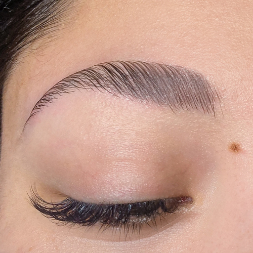 close-up of woman's closed eye area after brow lamination