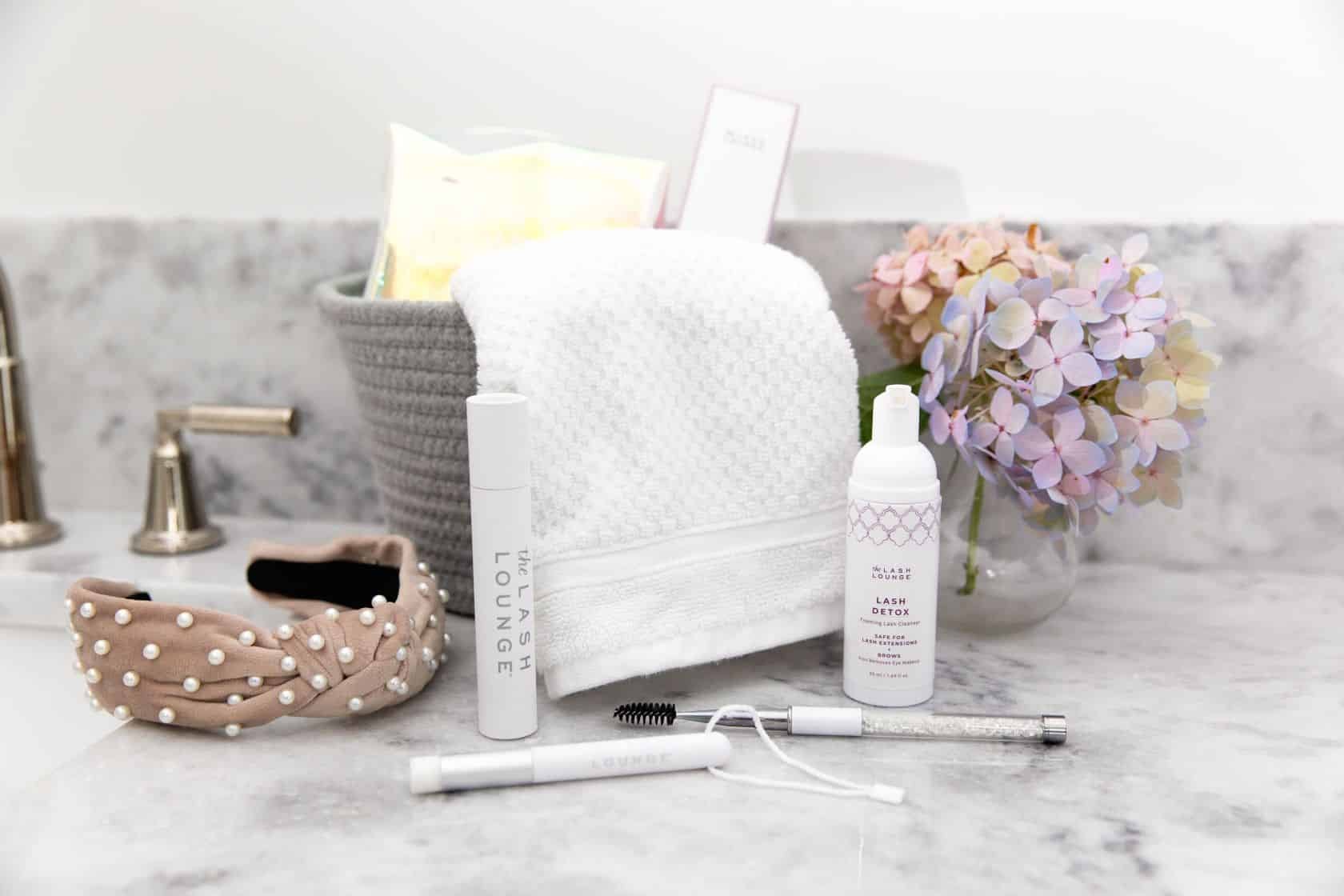 The Lash Lounge’s aftercare kit products sitting on a bathroom counter with other accessories.