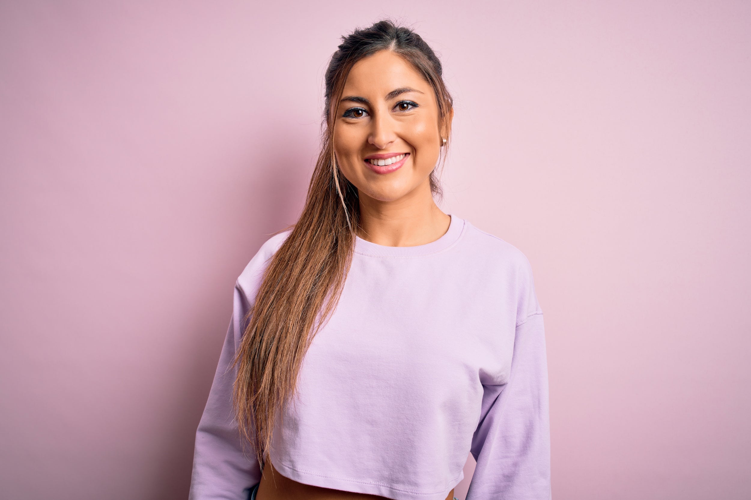 mid-shot young, happy woman with long ponytail and fresh brows